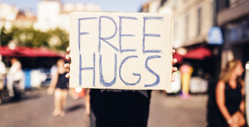 holding FREE HUGS sign in european city